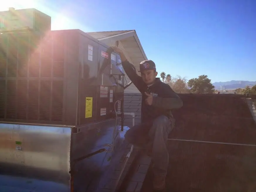 HVAC technician performing Air Duct Repair on a rooftop unit in Eagle